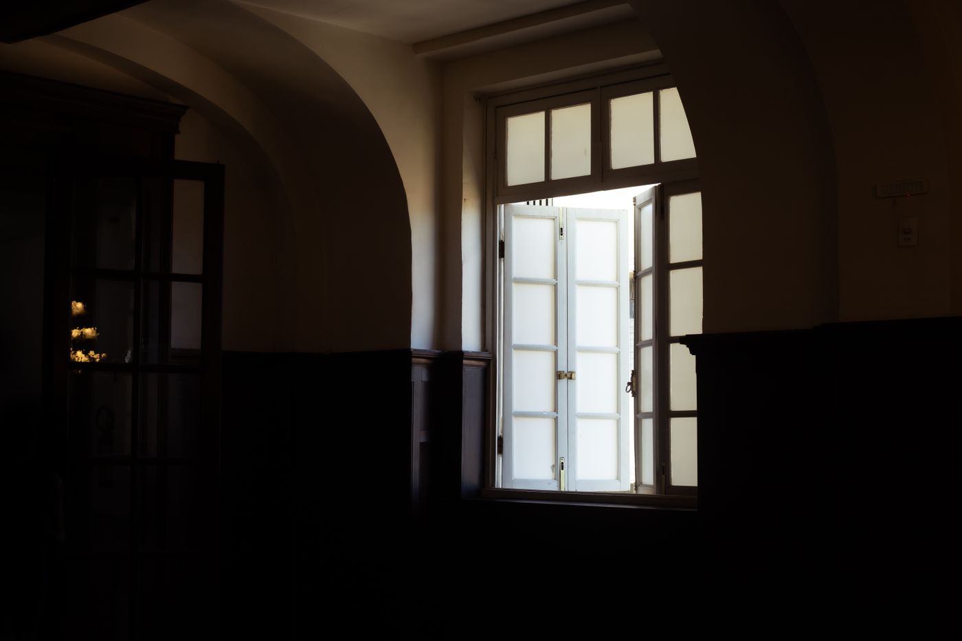 An open white-framed window letting daylight into a room